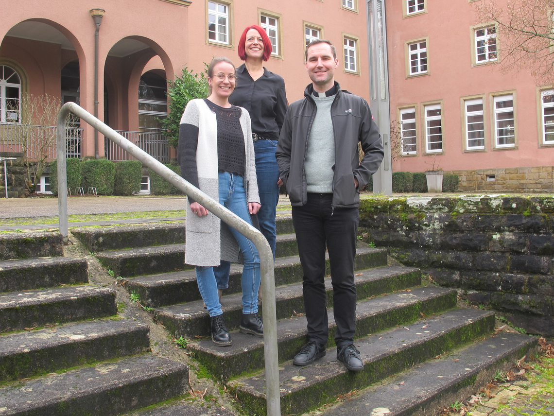 Peter Zillgen und sein Team stehen vor einem Gebäude